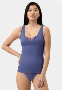 Fioletowy top na ramiączkach z dekoltem w serek oraz koronkowymi detalami przy dekolcie, w komplecie z dopasowanymi fioletowymi majtkami kąpielowymi z koronkowymi akcentami.