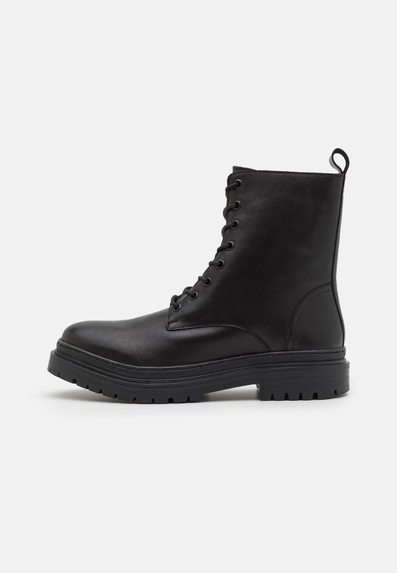 Bottes de combat en cuir noir avec un bout rond, un design à lacets, et une semelle en caoutchouc épaisse avec des crampons profonds pour une meilleure traction.