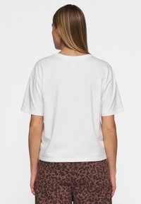T-shirt bianco in cotone con maniche corte e vestibilità rilassata, visto dal retro. Presenta un colletto rotondo e una texture liscia.