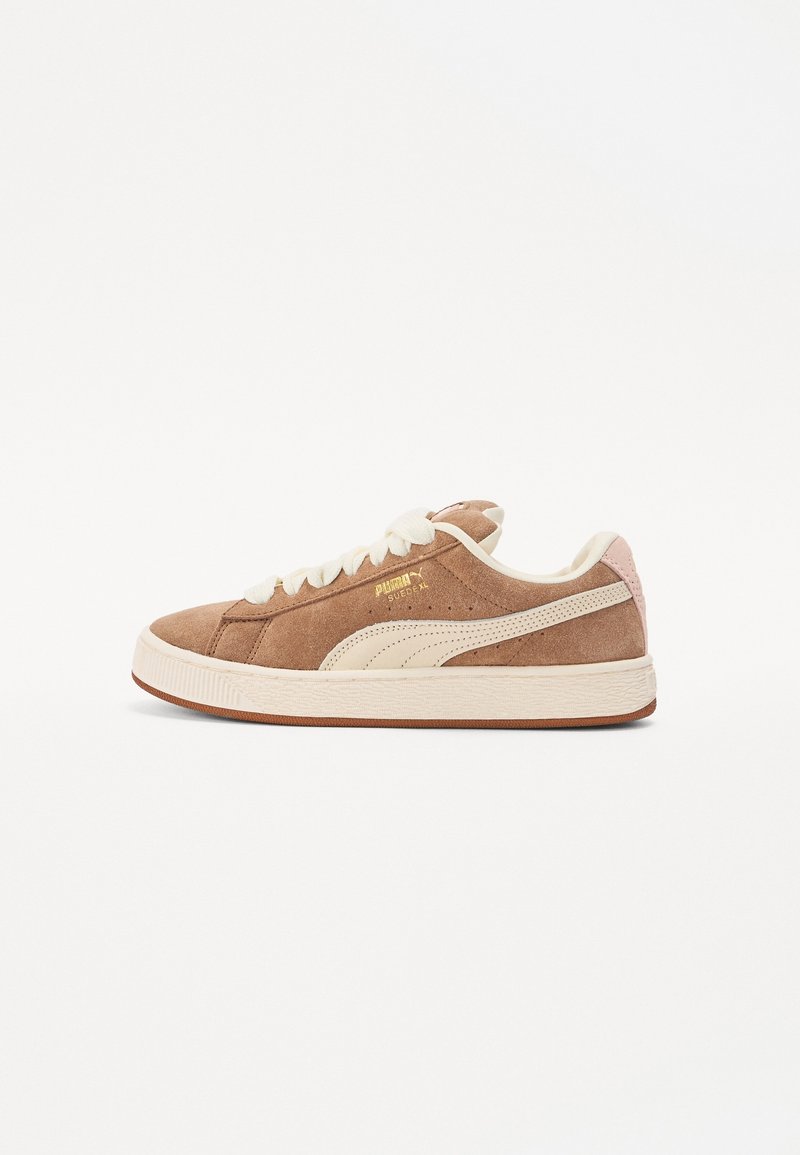 Baskets Puma en suède marron avec lacets crème, bande Puma crème, languette de talon rose et semelle en caoutchouc blanche, vues de côté.
