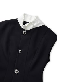 Czarna sukienka bez rękawów z białym satynowym kołnierzykiem. Ozdobiona srebrnymi akcentami i czarnymi kamieniami szlachetnymi z przodu, z wyraźnymi liniami i zarysowanym krojem.