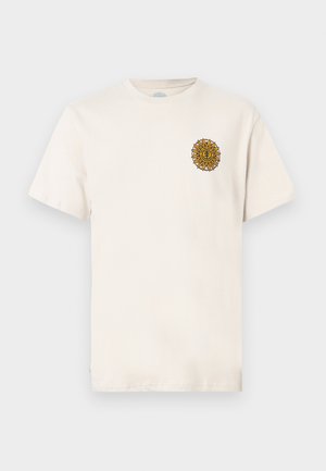 Offwhite kortermet t-skjorte med et lite gult og brunt sol-emblem på venstre brystområde mot en ensfarget bakgrunn.