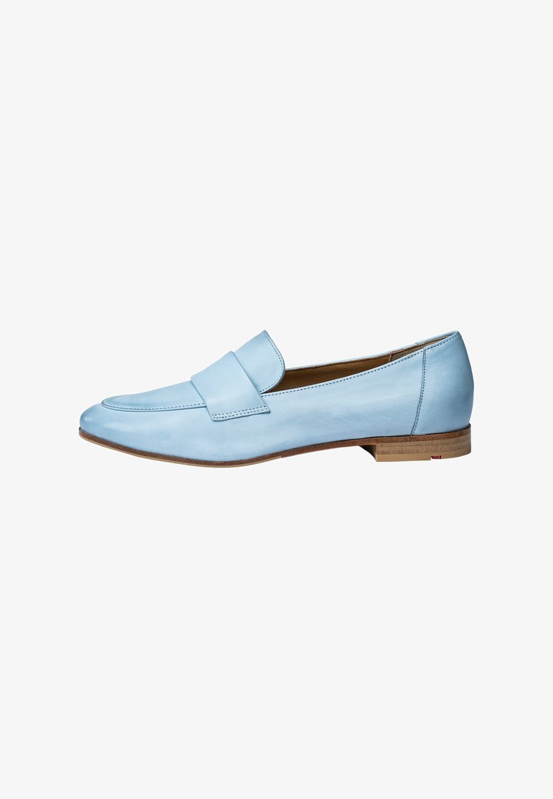 Mocasines de cuero azul claro con suela plana, puntera redondeada y una correa decorativa en la parte delantera. Textura suave, detalles de costura mínimos.
