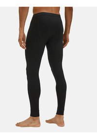 Leggings noirs avec une texture lisse, un design ajusté et des bas de jambe. Équipés d'une taille large pour plus de confort. Pas de motifs ou de logos visibles.