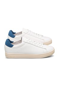 Vita lädersneakers med en krämfärgad sula och en blå mocka accent vid hälen. Har traditionell snörning och en slät yta för textur.