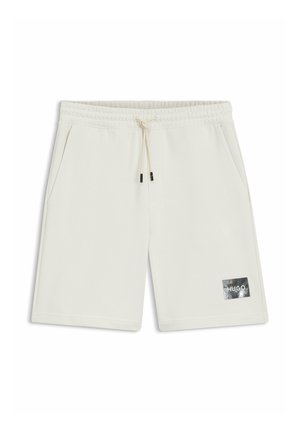 Off-white knee-length shorts with elastic waistband, drawstring, side pockets, and small black rectangular logo patch reading "HUGO" on left leg.