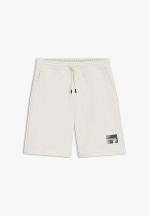 Off-white knee-length shorts with elastic waistband, drawstring, side pockets, and small black rectangular logo patch reading "HUGO" on left leg.