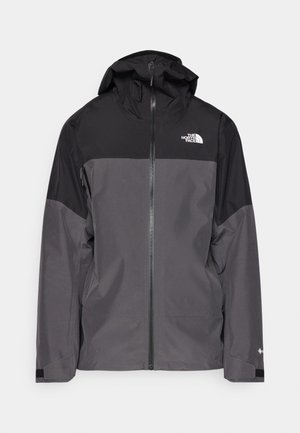 Pilkas vandeniui atsparus švarkas su juodu viršutiniu įdėklu, užtrauktuku priekyje, reguliuojamu gaubtu ir elastingomis rankovėmis. Yra logotipas ant krūtinės ir rankovės.