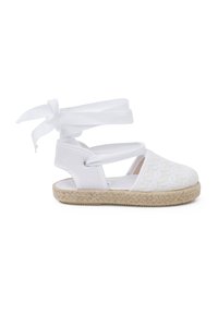 Sandal in espadrille bianca con tomaia in tessuto caratterizzata da un motivo intrecciato, nastri da legare alla caviglia e suola in stile juta per una finitura naturale.