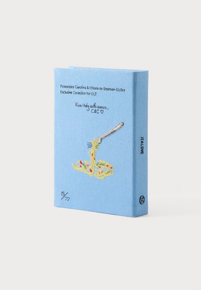 Μπλε εξώφυλλο βιβλίου με κεντημένο πιρούνι που τυλίγει σπαγγέτι, μικρές κόκκινες τελείες και κείμενο σχετικά με την αποκλειστική συλλογή Ιταλίας των πριγκιπισσών Καρολίνας και Κιάρας.