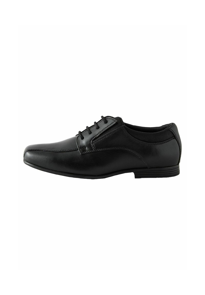 Chaussure noire avec un design épuré, dotée de lacets et d'un subtil éclat, posée sur un fond blanc. Convient pour des occasions formelles.
