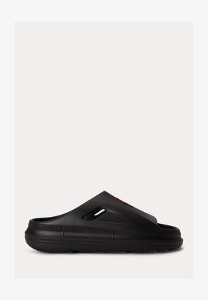 Μαύρο κλειστό παπούτσι τύπου clog με παχιά σόλα, πλευρικές οπές αερισμού και διαμορφωμένη πέλμα, σχεδιασμένο για καθημερινή χρήση.