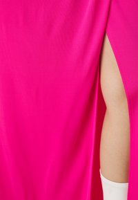 Fuksia rosa kjole med glatt stoff og sidesprocessor, akkompanjert av en tettsittende hvit erme som strekker seg fra under.