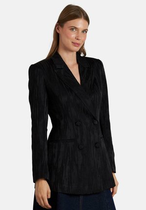 Blazer negro de doble botonadura con tejido texturizado, solapas marcadas y dos botones. Cuenta con bolsillos laterales y un corte ajustado.