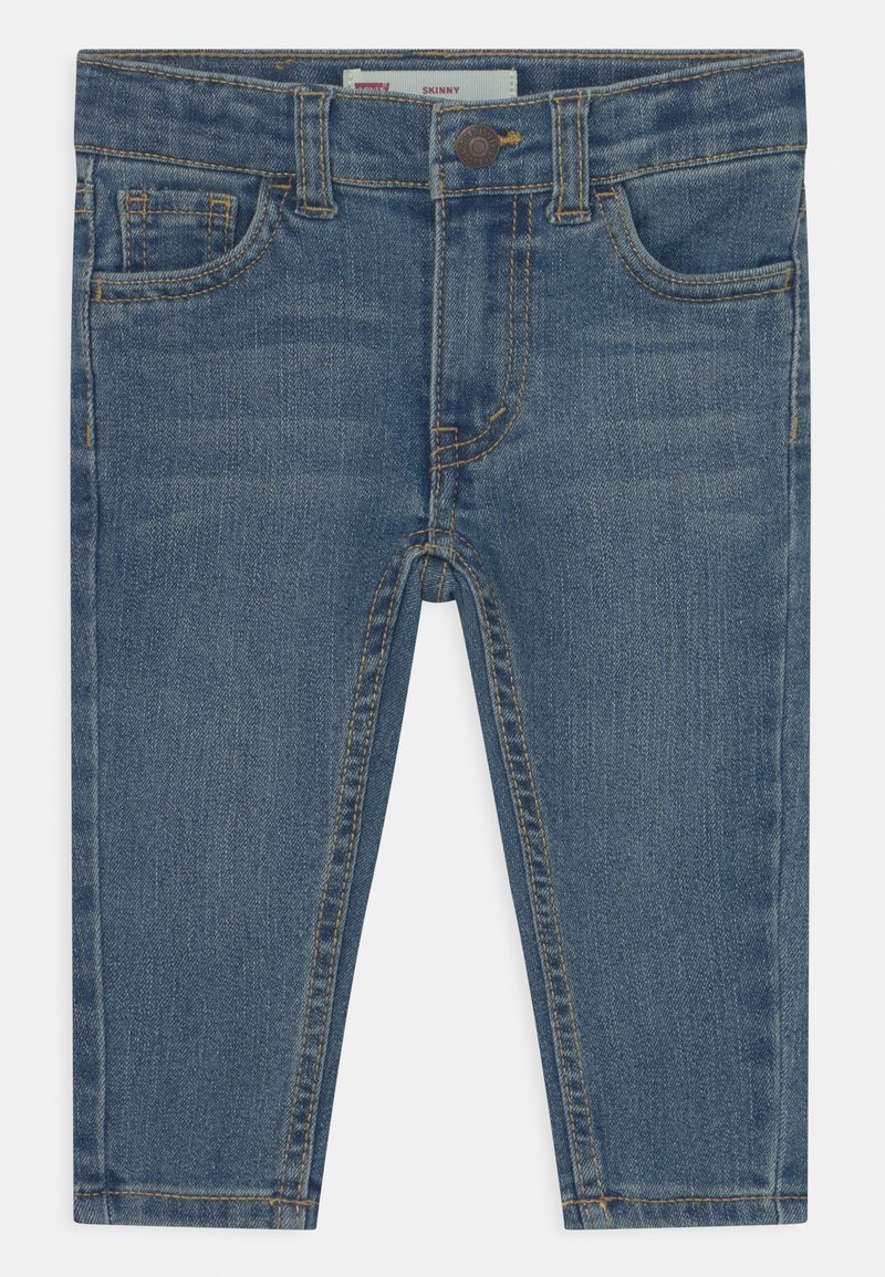 Jeans de denim ajustados en azul medio, con cinco bolsillos, cierre de botón y costuras en contraste. Textura suave con un ligero desgaste.