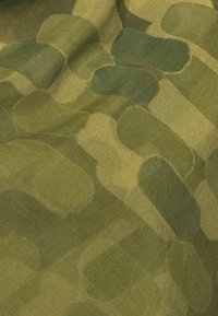 Tissu camouflage à texture douce, présentant des formes circulaires variées dans des tons de vert et de vert-jaune, créant un motif organique et mélangé.