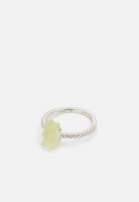 Hopeaketju hope ring, jossa on keltainen karkkihahmo, joka toimii keskipisteenä, ympärillä kiiltävä rivi kirkkaista kivistä.