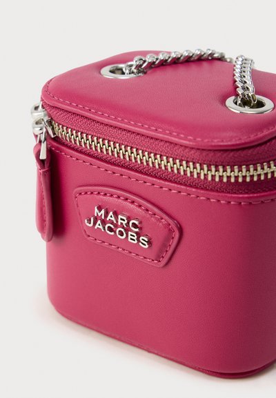 Ροζ τετράγωνη δερμάτινη τσάντα με ασημί εξαρτήματα, με φερμουάρ, αλυσίδα χειρολαβή και ανάγλυφο λογότυπο στο μπροστινό πάνελ.