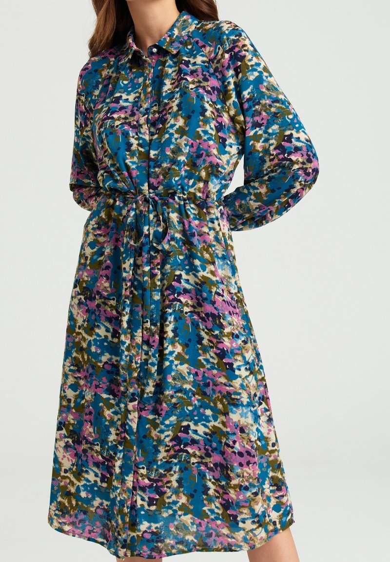 Robe midi à manches longues et col, motif floral abstrait bleu, rose, vert et crème, avec ceinture resserrée à la taille.