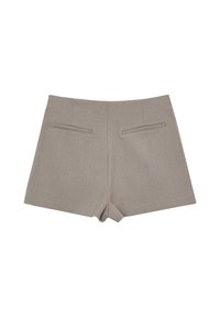 Shorts beige chiaro, sartoriali, con una texture liscia, dotati di due tasche posteriori e un orlo pulito. Nessuna chiusura visibile.