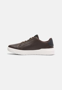 Barna bőr sneaker perforált oldalsó panelekkel, kerek orral, fehér talppal és sötétbarna sarok kiemeléssel. Fűzős dizájn minimális profilal.
