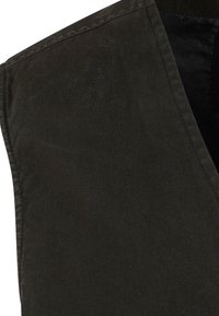 Ciemno oliwkowy bezrękawnik, wykonany z gładkiego materiału o lekko fakturowanym wykończeniu; posiada dekolt w kształcie litery V i czyste krawędzie.