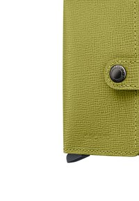 Grüne, strukturierte Geldbörse aus synthetischem Material mit Druckknopfverschluss und kontrastierenden schwarzen Metallakzenten.