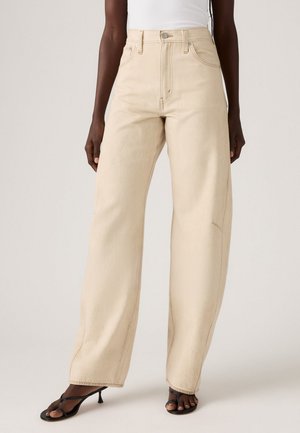 Beige wide-leg jeans made of denim; high-waisted with front pockets, visible stitching, and a slightly faded finish.