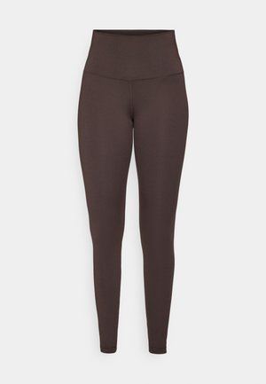 Brune høyhals leggings laget av et elastisk, glatt materiale. Har en tettsittende design uten synlige sømmer eller mønstre.