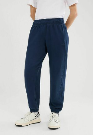 Pantalones de chándal azul marino hechos de material suave, con una cinturilla elástica, puños ajustados y bolsillos laterales para mayor comodidad.
