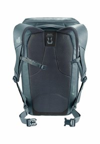 Grijze rugzak met een gepolsterde mesh achterkant, verstelbare schouderbanden en verschillende hardware-accenten. Heeft een geometrisch patroon op het oppervlak.