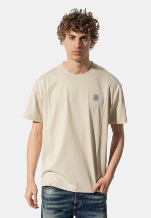 T-shirt beige in cotone a maniche corte con scollatura rotonda e un piccolo logo sul petto. Tessuto liscio, vestibilità morbida.