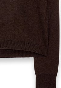 Brūns adīts džemperis ar ribotām aprocēm un apakšmalu. Audums ir mīksts un nedaudz elastīgs, ar brīvu piegriezumu un minimālu apdari.