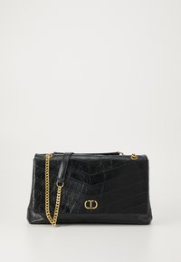 Black leather handbag with chevron pattern, gold chain strap, and branded hardware accent. Structured design with a zip closure.
