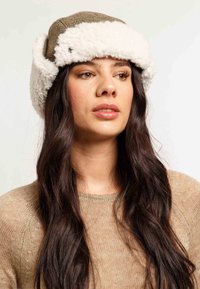 Brun tweed hat med hvid faux pels trim. Har en rund form og ørerne, der tilføjer varme og stil til designet.