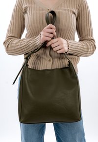 Olive green leather handbag with a smooth texture and sturdy handle, featuring a slight slouch and minimalistic design.