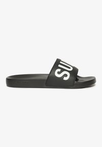 Sorte glide sandaler med mat finish, der har en bred rem med "SUPERDRY" i fede hvide bogstaver. Tekstureret sål for godt greb.