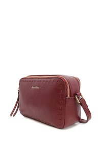 Borsa a bustina in pelle rossa con chiusura a zip, minuteria dorata e dettagli di cucitura lungo i bordi. Forma compatta e rettangolare.