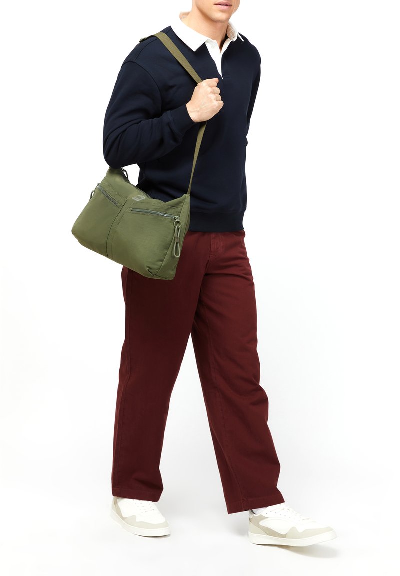 Borsa a spalla verde oliva con multiple tasche con zip, realizzata in tessuto morbido e testurizzato. Tracolla regolabile e dettagli di design puliti.