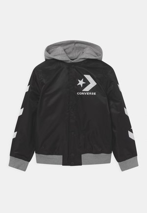 Schwarze Jacke mit Knöpfen, grauer Kapuze und Bündchen, weißes Chevron- und Sternlogo auf Brust und Ärmeln, "CONVERSE"-Schriftzug unter dem Logo.