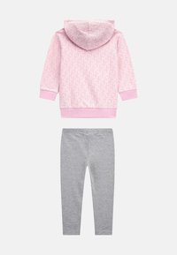 Világos rózsaszín kapucnis pulóver virágmintával, kapucnival és bordás mandzsettával, szürke leggingssel párosítva, puha, rugalmas anyagból készülve.