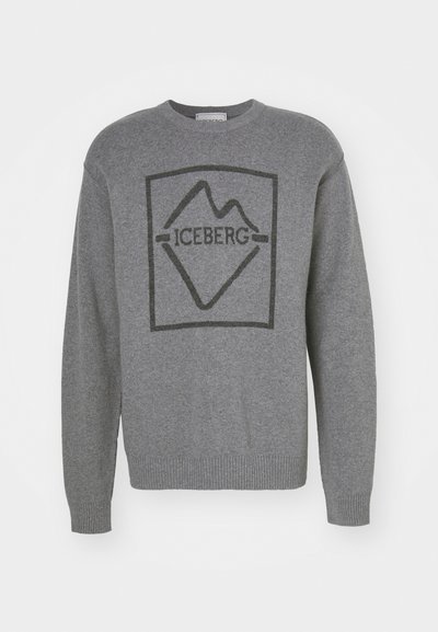 Pelēks džemperis ar melnu kalnu logo, kas atrodas taisnstūrveida robežās. Materiāls šķiet mīksts, ar ribotām aprocēm un apakšmalu.