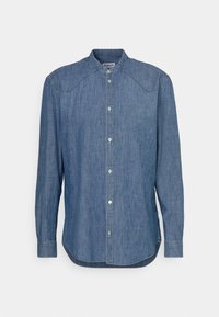 Jeansskjorta med knappar, lång ärm, mandarin-krage och rundad fåll. Har ljusblått tyg med subtil textur.