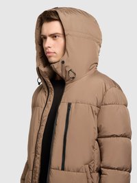 Bolvormige bruine winterjas met een grote capuchon, ritssluiting aan de voorkant en twee zakken met rits. Heeft een gladde, glanzende textuur en zwarte accenten.