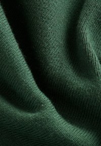 Donkergroen gebreide stof met een zachte textuur, met een ribbelpatroon en subtiele variaties in de draaddikte. Geen zichtbare patronen of hardware.