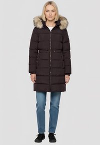 Manteau matelassé noir avec capuche amovible bordée de fourrure, doté d'une fermeture éclair et d'une taille cintrée. Texture douce et matelassée avec poches latérales.