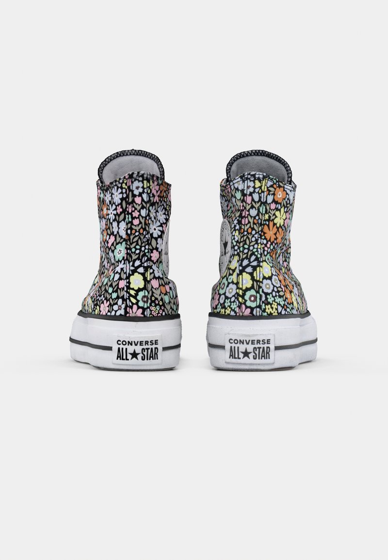 Baskets Converse montantes avec un motif floral de différentes couleurs sur fond noir. Semelle en caoutchouc blanc avec logo de la marque au talon.