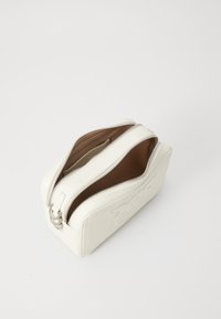 Borsa a tracolla rettangolare in pelle bianca con due scomparti aperti con zip e foderatura interna marrone su sfondo bianco.