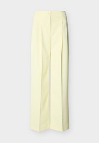 Ανοιχτό κίτρινο παντελόνι ευρέος ποδιού με ψηλή μέση, κλείσιμο με κουμπί και φερμουάρ μπροστά, και πιέτες, σε μονόχρωμο φόντο.