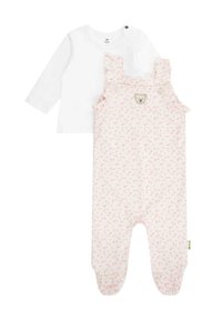 Bílá košile s dlouhým rukávem spárovaná s růžovými lacláči s květinovým vzorem a detailním knoflíkem ve tvaru medvěda. Měkká látka s volány na ramínkách.